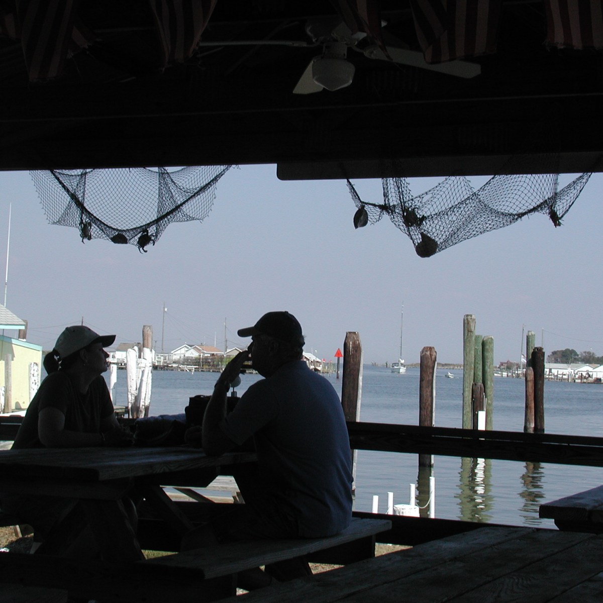 Two people eating on a dock on Tangier Island